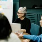 Smiling senior businesswoman leading a diverse team meeting in an office.