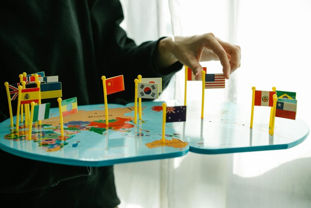 Hand arranging flags on a world map, The Essential Guide to Choosing an International SEO Agencysignifying global diversity.